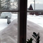 Iso lumikasa keittiön ikkunan edessä